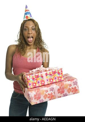 Eine junge Frau hält Geschenke und Hut eine Partei in einem Studio. Stockfoto