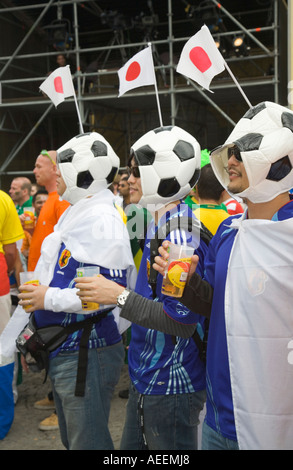 Drei japanische Fußball-Fans tragen Hüte, die aussehen wie Fußbälle in ein Fußball-Welt-Cup-public-Viewing-Event in Dortmund Stockfoto