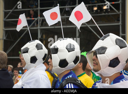 Drei japanische Fußball-Fans tragen Hüte, die aussehen wie Fußbälle in ein Fußball-Welt-Cup-public-Viewing-Event in Dortmund Stockfoto