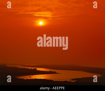 ein noch sich windender Fluss mit einem dramatischen roten Himmel und aufgehende Sonne darüber Stockfoto