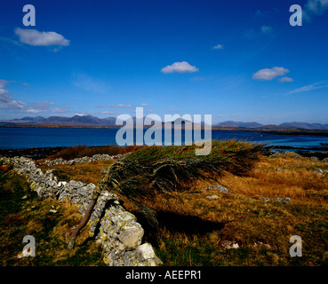 Landschaftsfoto mit Steinmauer und Feld mit Blick auf See und Berge Stockfoto