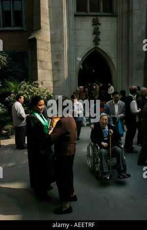 Die Priesterin grüßt die Gemeindemitglieder nach dem Gottesdienst in der Mu En katholische Kirche in Shanghai Stockfoto