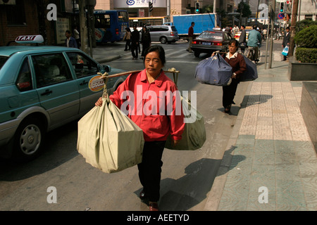 Shanghai China Frauen Träger die Güter in der Nähe von der Nanjing Road Stockfoto