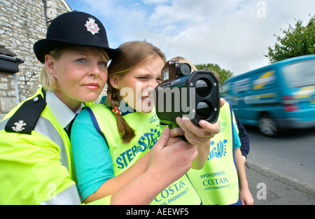 Schülerinnen und Schülern mit einen mobilen Blitzer unter der Aufsicht eines weiblichen Polizeibeamten am Straßenrand in South Wales UK Stockfoto