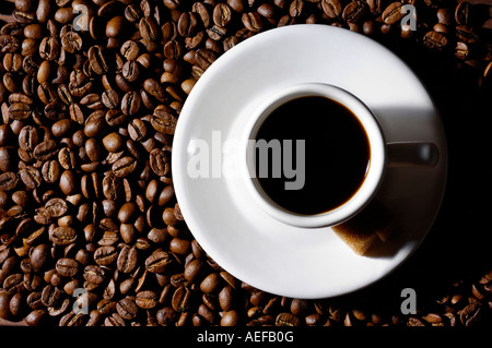 Weiße Tasse schwarzen Kaffee auf Untertasse auf Kaffeebohnen abstrakten Hintergrund Stockfoto