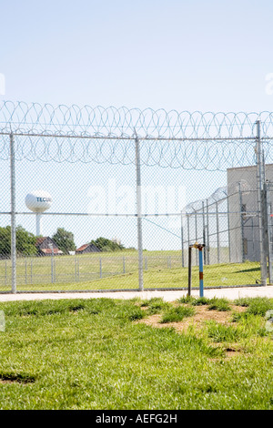 Umzäunung am maximale Sicherheit Tecumseh State Correctional Institution Nebraska USA Wasserturm im Hintergrund Stockfoto