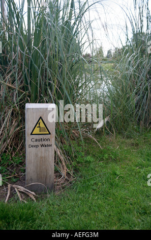 Schild Warnung des Tiefenwassers am großen Gartenteich. UK Stockfoto