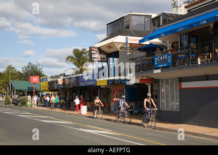 Moderne Uferpromenade Geschäfte, Bars und Restaurants auf Marsden Straße mit Radfahrern Paihia "Bay of Islands" Nordinsel Neuseeland Stockfoto