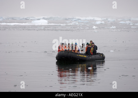 Touristen kommen an ein Gentoo-Pinguin-Kolonie von Zodiac westlichen Antarktischen Halbinsel Antarktis Southern Ocean Stockfoto