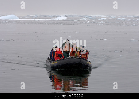 Touristen kommen an ein Gentoo-Pinguin-Kolonie von Zodiac westlichen Antarktischen Halbinsel Antarktis Southern Ocean Stockfoto