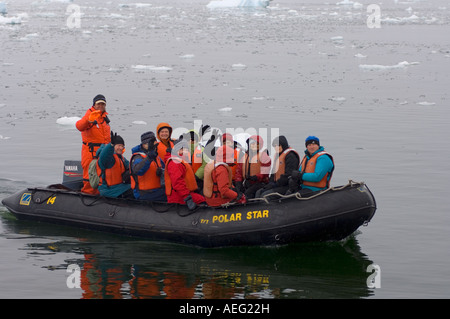 Touristen kommen an ein Gentoo-Pinguin-Kolonie von Zodiac westlichen Antarktischen Halbinsel Antarktis Southern Ocean Stockfoto