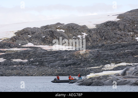 Touristischen kommen bei einem Gentoo Penguin Pygoscelis Papua Kolonie von Zodiac westlichen Antarktischen Halbinsel Antarktis Southern Ocean Stockfoto