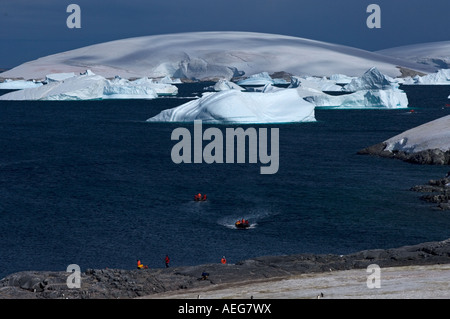 Touristen aus der National Geographic Expedition Schiff Unterfangen Check-out ein Gentoo-Pinguin Pygoscelis Papua Kolonie stand Insel Stockfoto