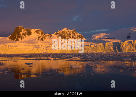 Sonnenuntergang bedeckt die Berge Gletscher Felsen Schnee Wasser Eisberge und Eis an der Küste der Antarktis westantarktische Halbinsel Südmeere Stockfoto