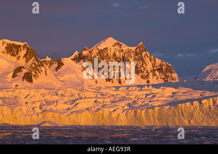 Sonnenuntergang bedeckt die Berge Gletscher Felsen Schnee Wasser Eisberge und Eis an der Küste der Antarktis westantarktische Halbinsel Südmeere Stockfoto