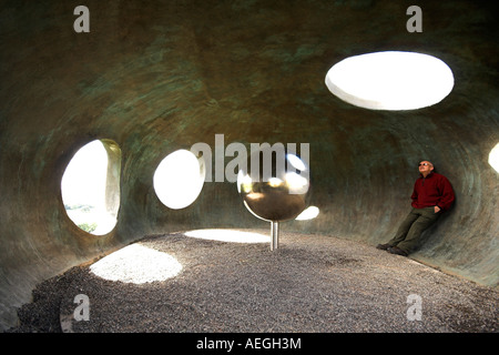 Mann, der in einer Skulptur, das Atom, Panoptikum, Wycoller Country Park, Pendle, UK Stockfoto