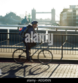 Dem Rad zur Arbeit am frühen Morgen über London Bridge keine Modellfreigabe erforderlich als Gesicht unkenntlich über verzerrte Unschärfe und Schatten Stockfoto