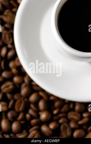 Weiße Tasse schwarzen Kaffee auf Untertasse auf Kaffeebohnen Stockfoto