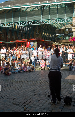 Vertikale Nahaufnahme von einem Straßenkünstler unterhalten die Massen auf der Piazza in Covent Garden an einem sonnigen Tag Stockfoto