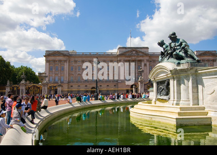 Horizontalen Weitwinkel von Touristen sitzen am Rande der "Queen Victoria Memorial" infront von Buckingham Palace. Stockfoto