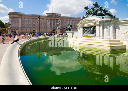 Horizontalen Weitwinkel von Touristen sitzen am Rande der "Queen Victoria Memorial" infront von Buckingham Palace. Stockfoto