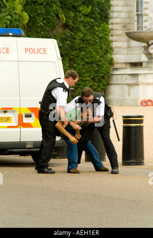 Vertikale Nahaufnahme eines Mannes kämpfen mit der Polizei, als er Verhaftung im Zentrum von London widersteht Stockfoto