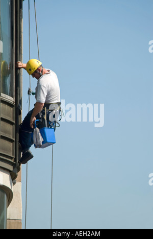 Vertikale Nahaufnahme von Fensterputzer baumelt prekär, saubere Fenster Stockfoto