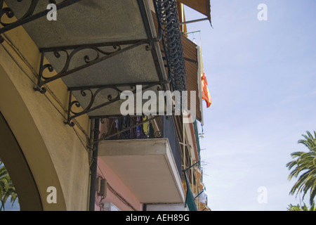 Schmiedearbeiten unter den Balkonen der malerischen und bunten Häuser in der Stadt Loano in Siesta-Zeit in Ligurien, Italien Stockfoto