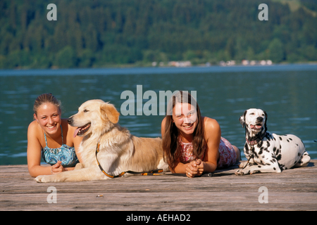 zwei Mädchen mit Dalmatiner Hund und Hovawart auf Steg Stockfoto