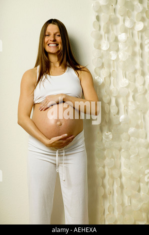 Schwangere Frau mit Händen am Bauch Stockfoto