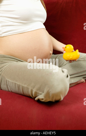 Schwangere Frau mit Gummiente Stockfoto