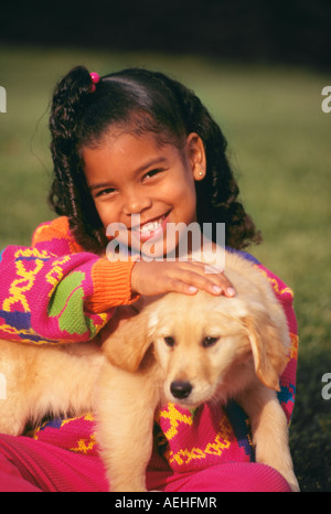 Nahaufnahme Nahaufnahme diverse Vielfalt süßes Mädchen 7-9 Jahre alten Holding Welpen lächelnd Portrait cute pet HERR © Myrleen Pearson Stockfoto