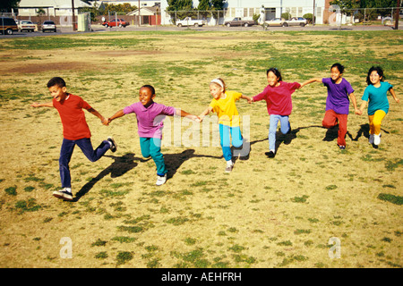 Junge Mensch Menschen Gruppe von ethnisch verschieden Kinder 7 8 9 Jahre Jahre alt halten sich an den Händen läuft lächelnd Spaß POV HERR © Myrleen Pearson Stockfoto