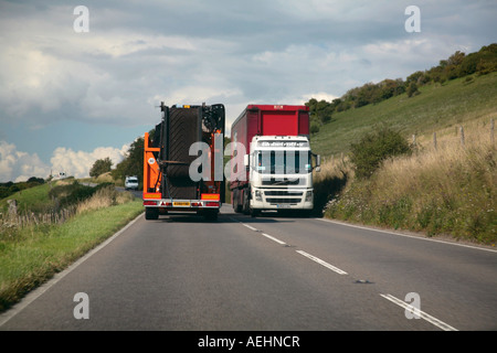 Zwei schwere Güterfahrzeuge auf einer schmalen englischen Landstraße vorbei Stockfoto