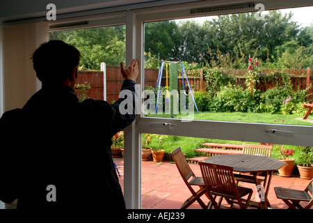 Ein junger Mann als Landvermesser arbeiten macht eine Umfrage einer Neubau Immobilie vor einem Hausverkauf. Stockfoto