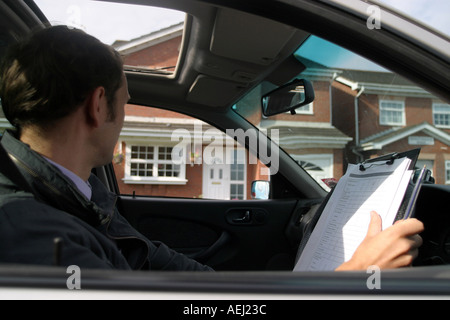 Ein junger Mann als Landvermesser arbeiten macht eine Umfrage einer Neubau Immobilie vor einem Hausverkauf. Stockfoto