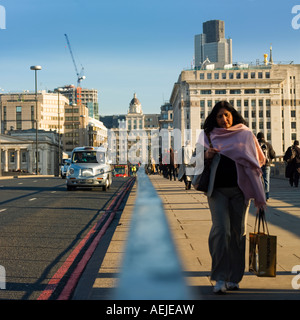 Frau am frühen Morgen Büroangestellte zu Fuß über die London Bridge 2007 arbeiten Stockfoto