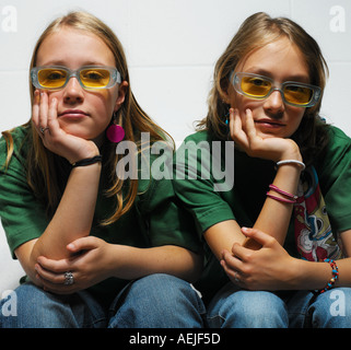 zwei Mädchen im Teenageralter Zusammensitzen auf weißen sofa Stockfoto