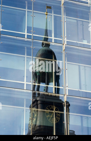 Der Turm der St. Michaelis Kirche spiegelt sich in der Glasfront eines modernen Bürogebäudes, Hamburg, Deutschland Stockfoto