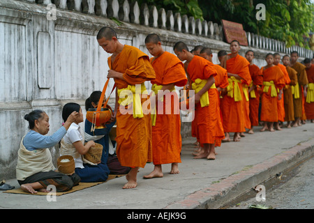 Mönche und Novizen betteln um ihre tägliche Nahrung in Luang Prabang, Laos Stockfoto