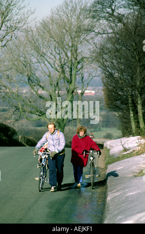 Cheshire Pott Shrigley Winter Radfahrer drängen Fahrräder steil bergauf wandern Stockfoto