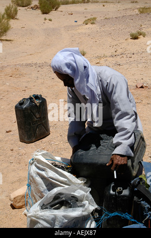 Ein Nachfüllen von Wasser in ein Kunststoff-Kanister in Wüste Sinai Ägypten ägyptischen Beduinen-Mann Stockfoto