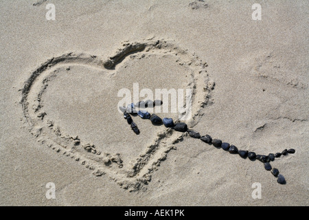 Ein Herz in den Sand mit einem Pfeil aus Steinen gemacht Stockfoto