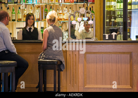 ALLGEMEINES BILD DES PAARES SITZEN IN EINER BAR Stockfoto
