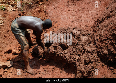 Junge Balck afrikanischen Mann mischen Lehm, Ziegel im Westen Kenias an der Seite der Straße Kisumu Maseno in Kenia machen Stockfoto