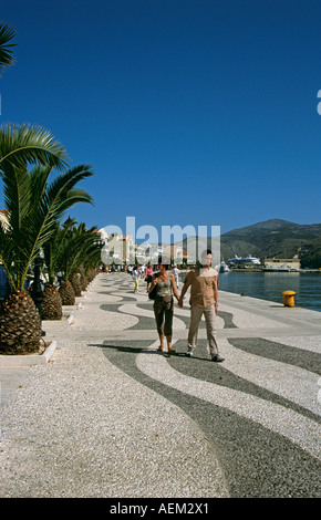 Touristen, die Hand in Hand zu Fuß entlang der Uferstraße, Argostoli, Kefalonia, Griechenland Stockfoto