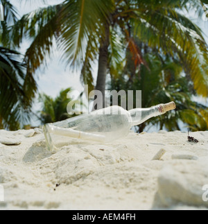 Eine Flaschenpost in den Sand an einem tropischen Strand. Stockfoto