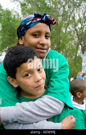 Liebevolle Latina Frau umarmen Sohn Alter in Boys and Girls Club parade Einheit. Cinco De Mayo Fiesta. "St. Paul" Minnesota USA Stockfoto