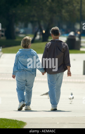 Ehepaar gehen Hand in Hand an einem sonnigen Tag Stockfoto