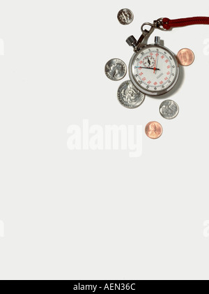 Zeit und Geld auf die weiße Fläche, Stoppuhr und Münzen, Stillleben Stockfoto